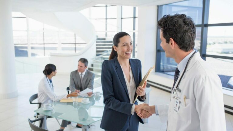 Doctor and businesswoman shaking hands